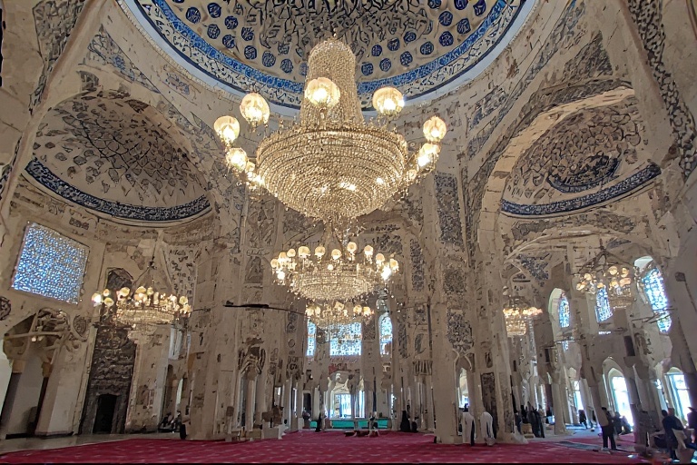 Interior of the Blue Mosque Dubai showcasing ornate chandeliers and Islamic calligraphy.